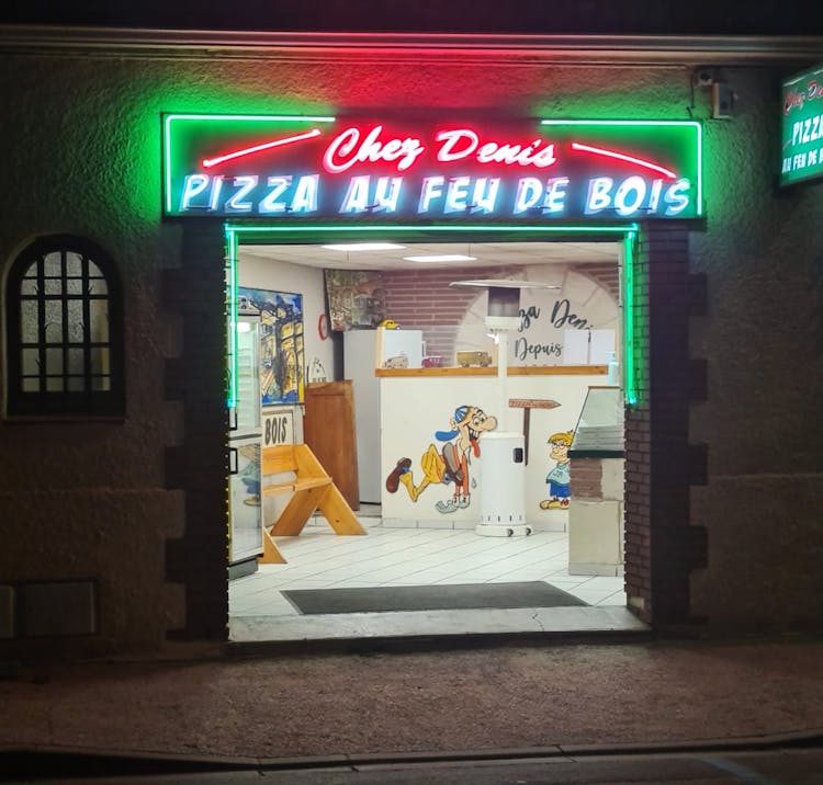 La facade du magasin Pizza Denis de nuit